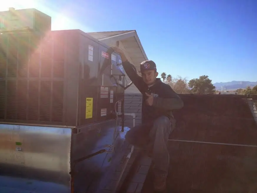 HVAC technician performing AC Tune-Up on a rooftop unit in Bay Minette